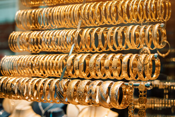 A jewelry store showcase with golden jewelry, bracelets and accessories. The concept of investments and savings with gold.
