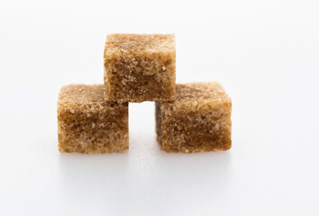 Brown sugar cubes on white background