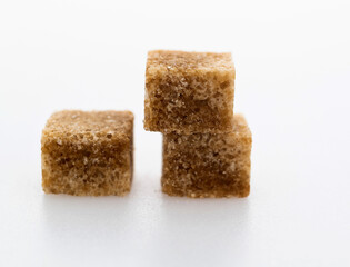 Brown sugar cubes on white background