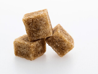 Brown sugar cubes on white background
