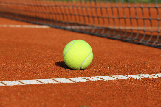 Symbolbild Tennis: Nahaufnahme von einem Tennisball auf einem Sandplatz