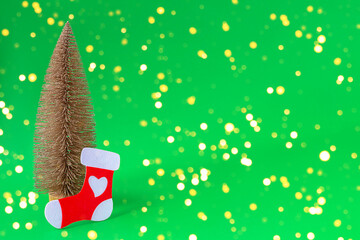 Christmas tree and sock on a green background in blurred lights