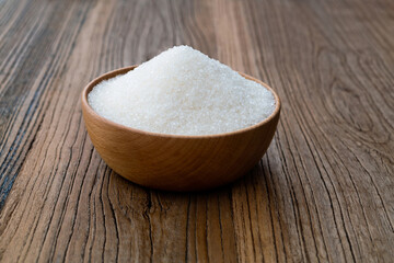 Granulated sugar in a bowl on wooden table