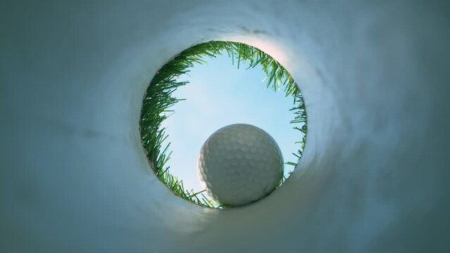 Super Slow Motion Shot of Golf Ball Falling Down Through Hole at 1000 fps.