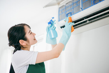エアコン掃除をする清掃業の女性

