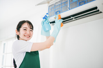 エアコン掃除をする清掃業の女性
