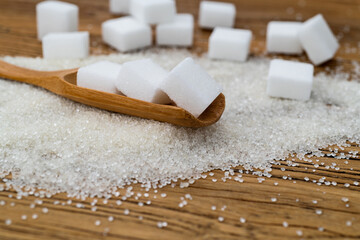 Scoop with sugar cubes on top of granulated sugar