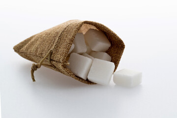 Sugar cubes in sack bag on white background