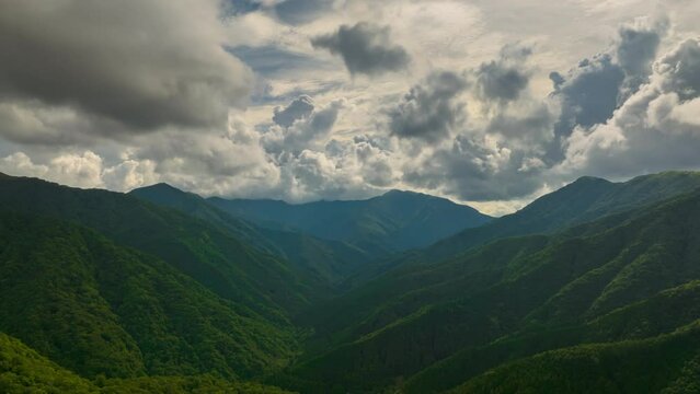 Hyperlapse: Clouds boil over green mountain landscape