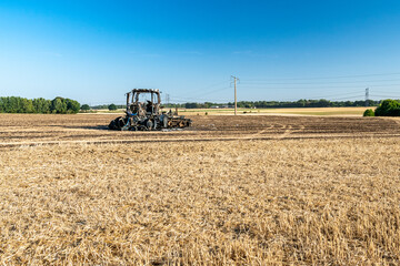 Feux de champs, carcasse de tracteur et d'un déchaumeur calciné suite à un incendie de chaumes lors de forte canicule