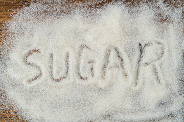 The word sugar written on granulated sugar