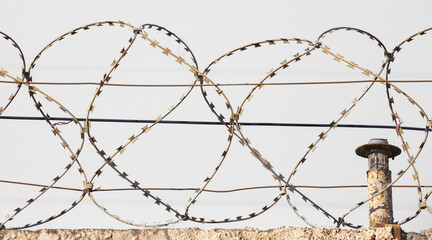 Barbed wire on the background of the sky close-up. Protected area, entrance is prohibited. Danger...