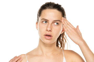 Portrait of confused charming young woman touching forehead ask you to remember think isolated on white background.