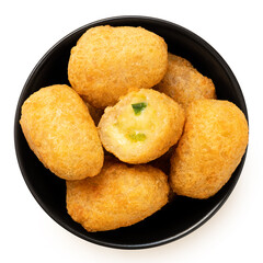 Fried breaded chilli cheese nuggets in a black ceramic bowl isolated on white from above. One eaten.