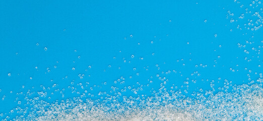 White sugar crystals on blue background