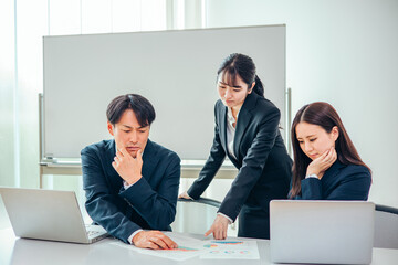 会議で問題点を話し合うビジネスチームの男女
