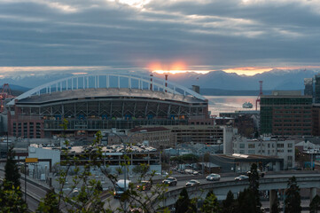 Sunset over Centurylink field stadium, two ferries in Puget Sound and Olympic National Park from...