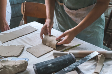 Potter makes dishes from clay, ceramics.Craft,work by hand in the workshop.Do it yourself products from ceramics.Close up of human hands making a clay bowl. Pottery teaching class