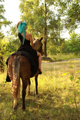Woman with blue hair riding a horse