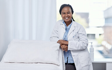 Happy doctor leaning on a hospital bed smiling, standing and ready to serve, assist and help you...