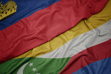 waving colorful flag of comoros and national flag of liechtenstein.