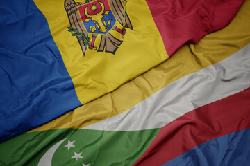 waving colorful flag of comoros and national flag of moldova.