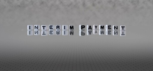 interim payment word or concept represented by black and white letter cubes on a grey horizon...