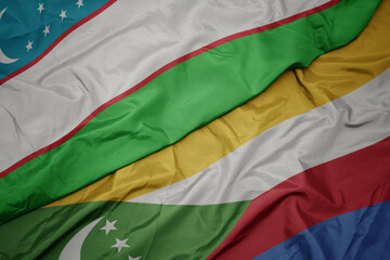 waving colorful flag of comoros and national flag of uzbekistan.