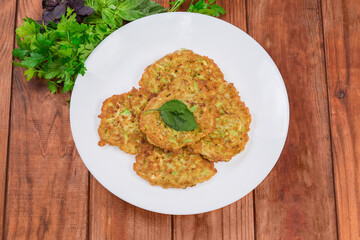 Savory thick zucchini pancakes on dish on old rustic table