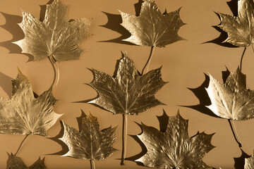 Autumn composition. Pattern made of autumn golden marple leaves on nude color background. Flat lay, top view, copy space