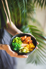 Asian food. Bowl with salmon, avocado, peas and seaweed. Food photography