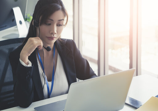 Asian Operator, Customer service assitance is answering call from client over internet computer call.