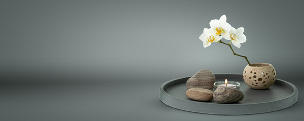 beautiful floral home decoration with white orchid and candle on grey pure background, lifestyle...