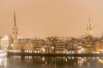 Altstadt in Zürich über der Limmat, Schnee und Sturm, die Kirchen St. Peter und Fraumünster im Spiegel des Wassers
