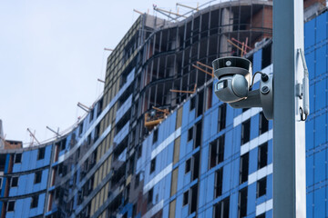 security CCTV camera or surveillance system with construction site on blurry background.