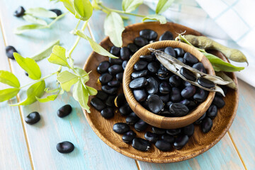 Raw organic vegetables. The concept of vegan or diet food. Fresh ripe black soy beans on a wooden table.
