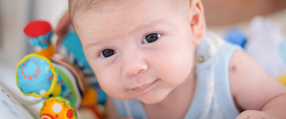 Close-up detail portrait of cute little peaceful newborn baby boy is lying on its stomach. Love and family emotion