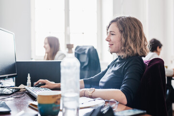 Yound devoted female software developers team working on desktop computer in IT statup company.