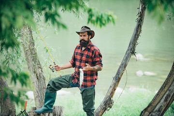 Fishing hobby and summer weekend. Portrait of bearded men fisher with fishing rod and net. Angler.