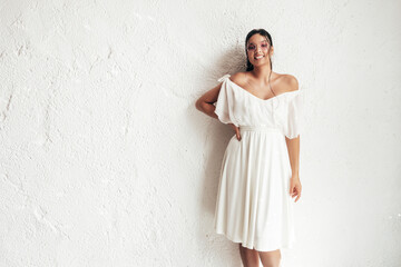 Young beautiful smiling female in trendy summer dress clothes. Sexy carefree woman posing near white wall in studio. Positive model having fun and going crazy. Cheerful and happy