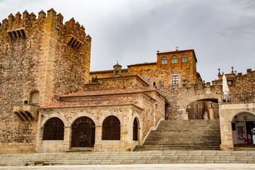 Fototapeta na wymiar Escalera y plaza con gran arco y edificios de arcos redondeados