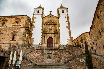 Fototapeta na wymiar Iglesia con fachada de piedra y torres blancas sobre escaleras de piedra