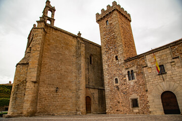 Torre antigua de piedra de convento con iglesia aledaña