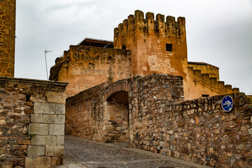 Fototapeta na wymiar Torre de castillo sobre muros de piedra beige