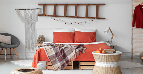 Modern interior of light room with big comfortable bed and autumn decor