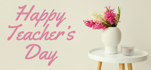 Vase with hyacinth flowers and candle on table against light background. Happy Teacher's Day