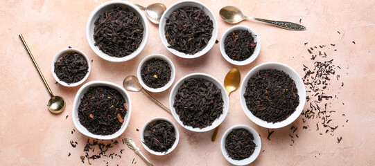Bowls with dry tea leaves on light color background, top view