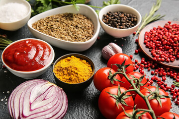 Fresh aromatic spices and vegetables on dark background