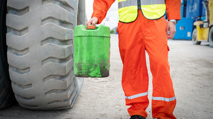 Foreman holding Lubricant in old Gallon tank in warehouse Shop
