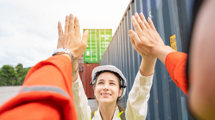Obraz premium Success Woman manager and foreman Trust hand Hi Five hand after success project logistics business in front of Cargo concainer in warehouse , Manager in white helmet Safety Supervisor warehouse